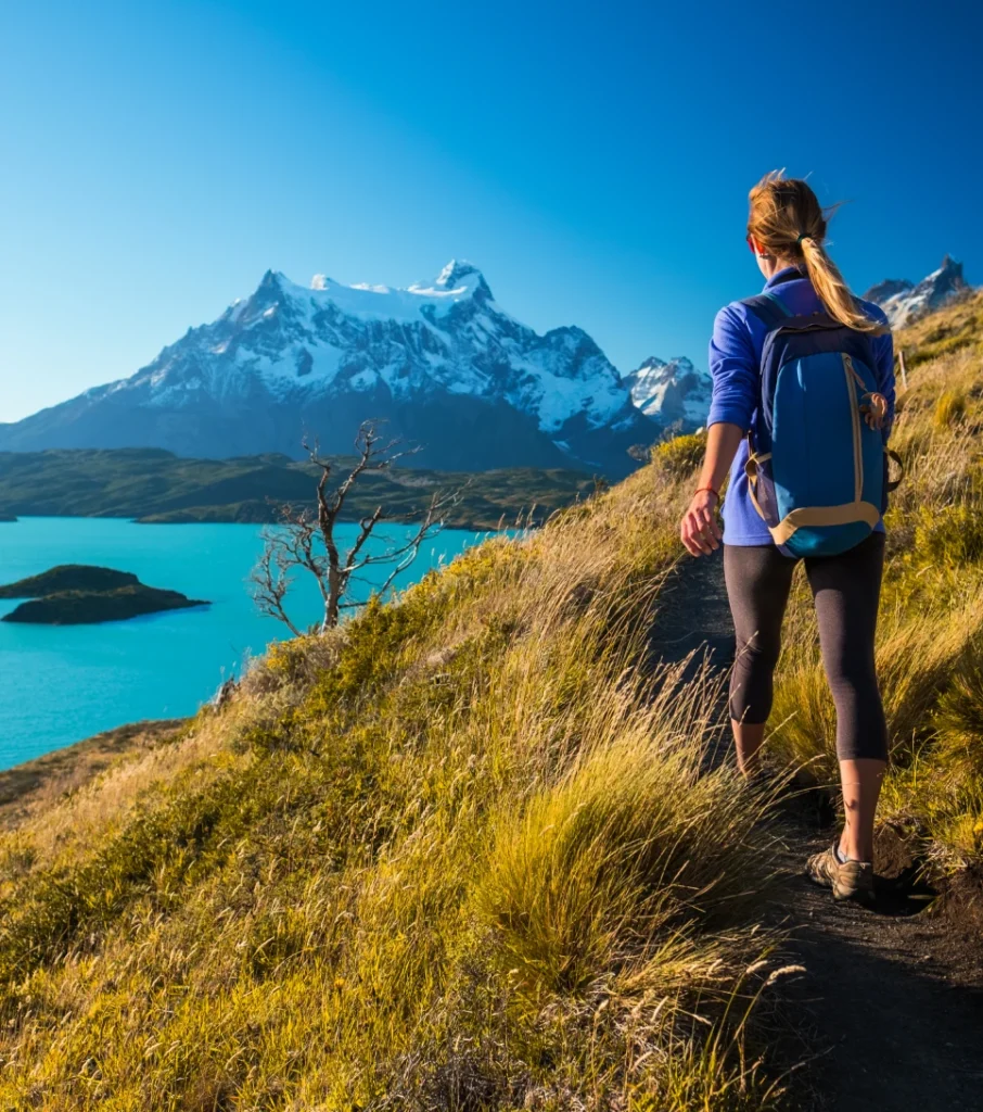 Hiker on a trail overlooking Torres del Paine lake, Patagonia